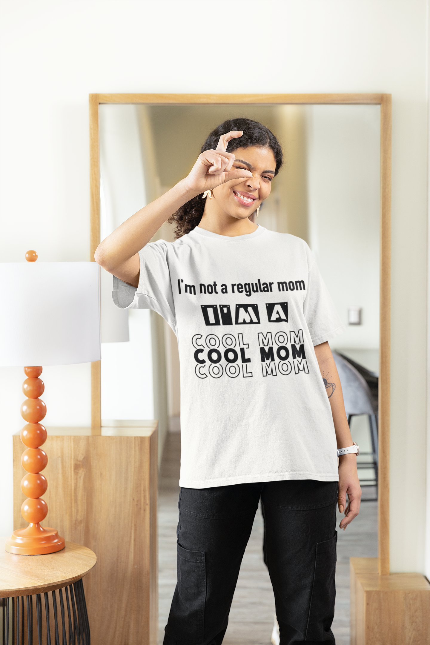 a mom wearing a white tshirt that has a slogan saying I'm not a regular mom I'm a cool mom
